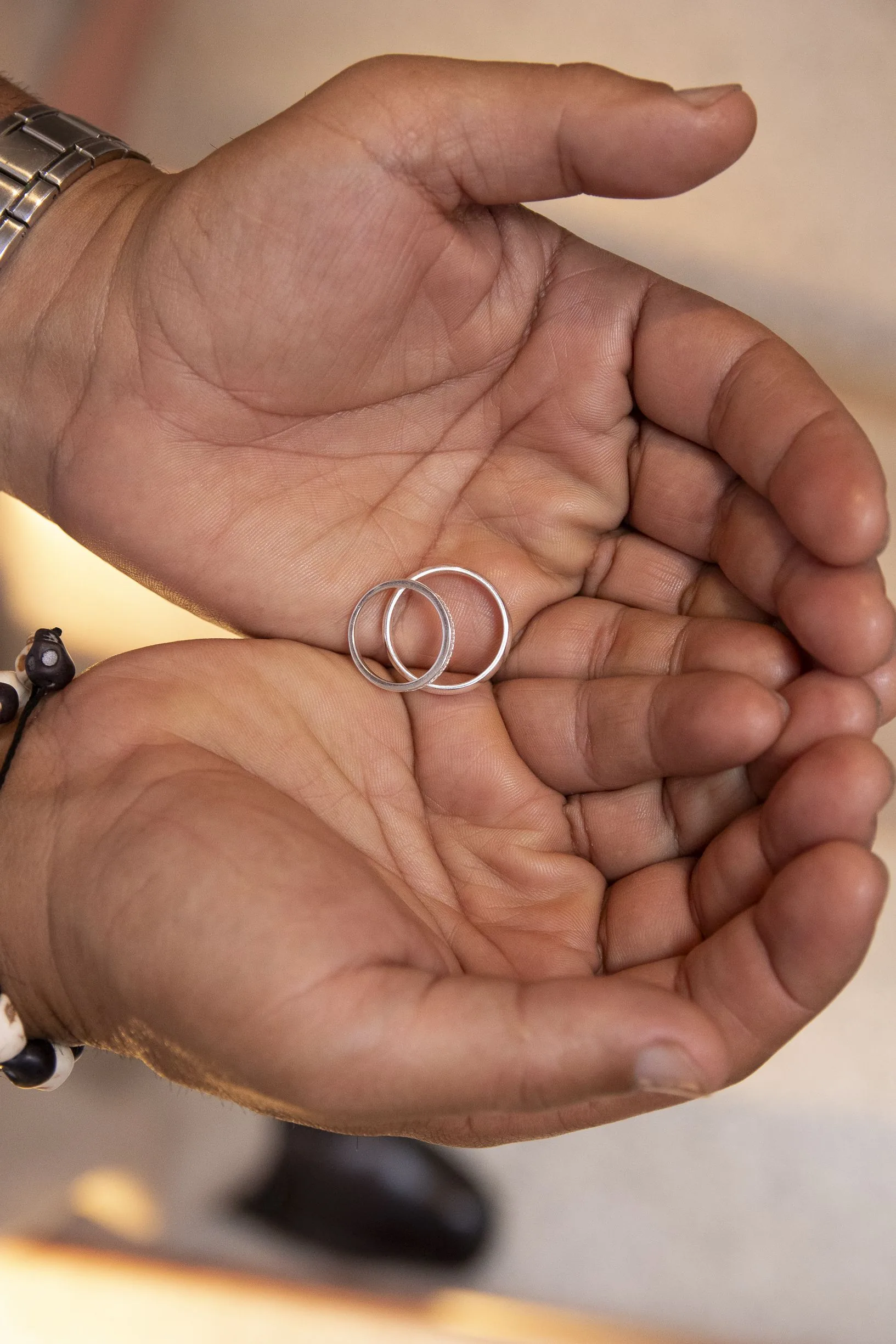 Las dos argollas de matrimonio sostenidas en la palma de la mano