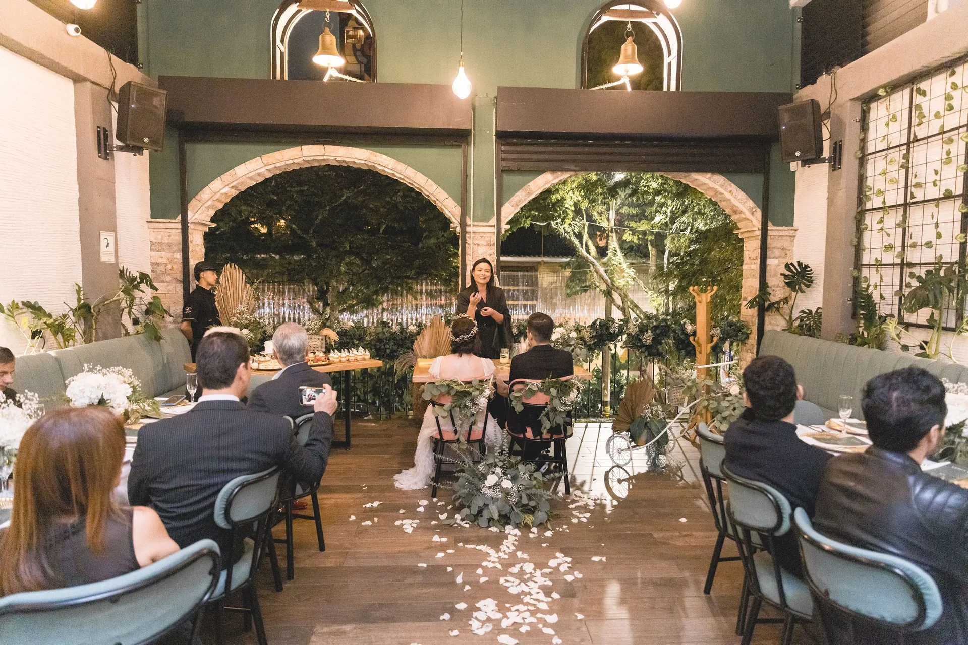 Ceremonia de boda bajo los arcos de ladrillo de Kampanas, con velas y los invitados sentados