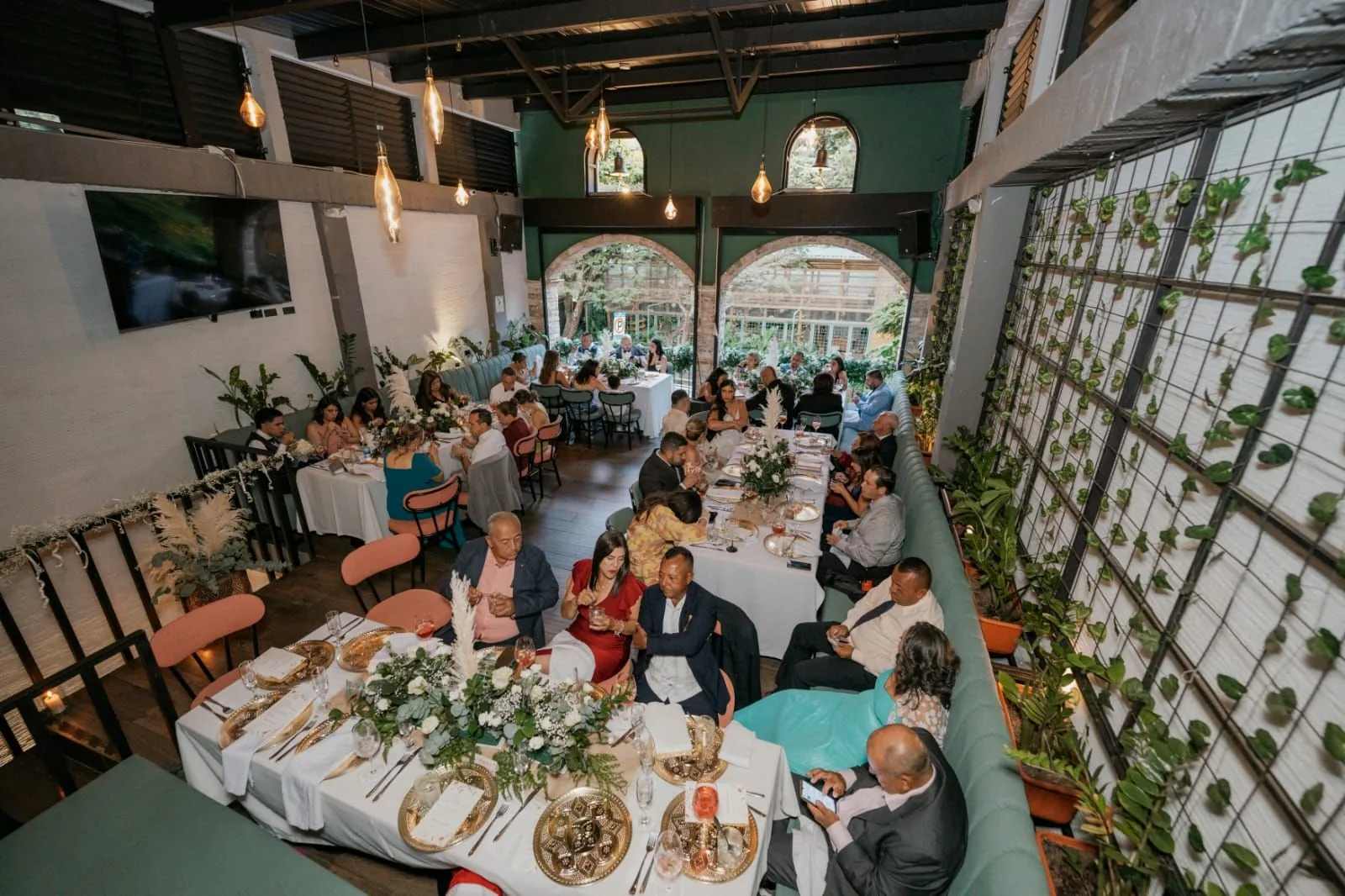 Mesa larga con los invitados celebrando en el salón