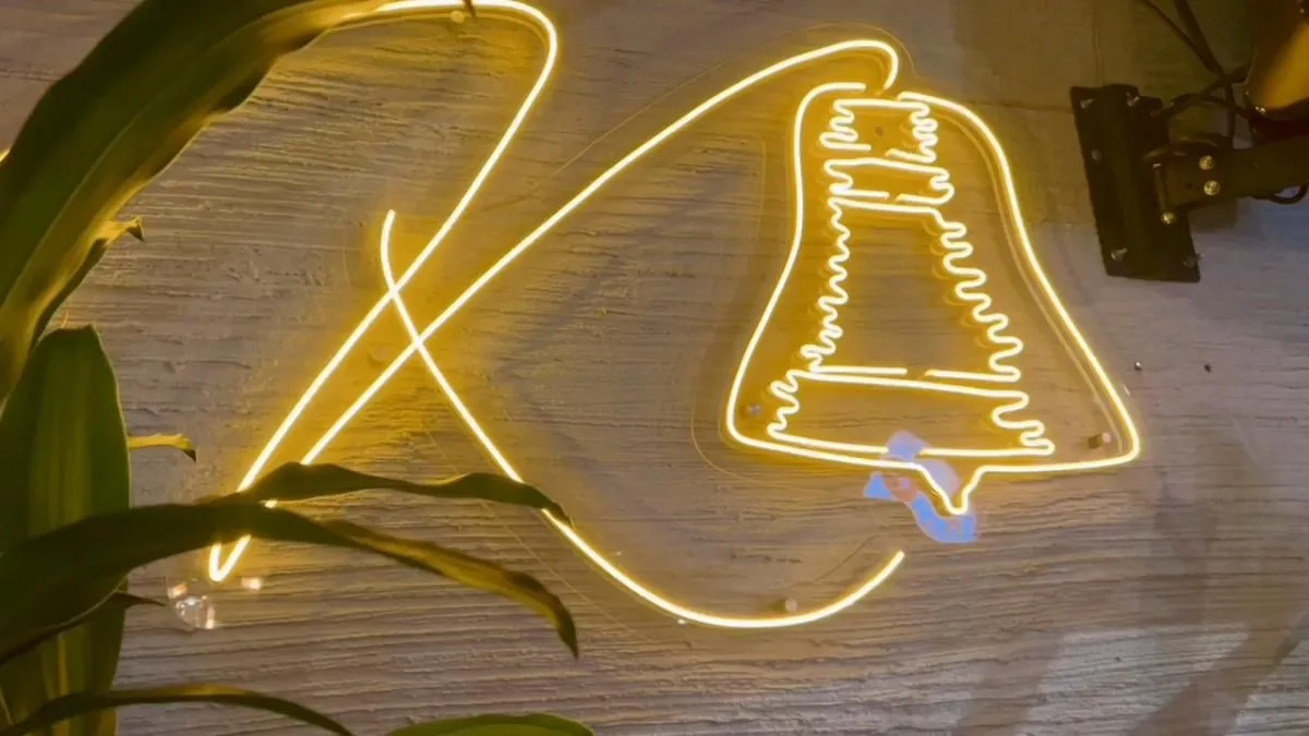Aviso de neón con la campana de Kampanas encendido durante la fiesta