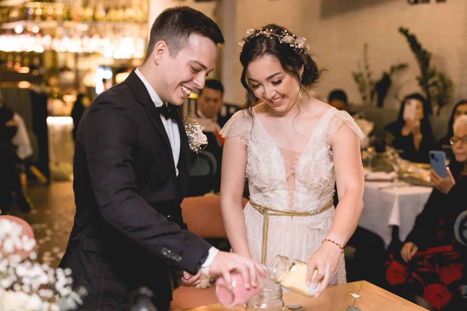 Los novios en la ceremonia de la arena, rodeados de sus invitados