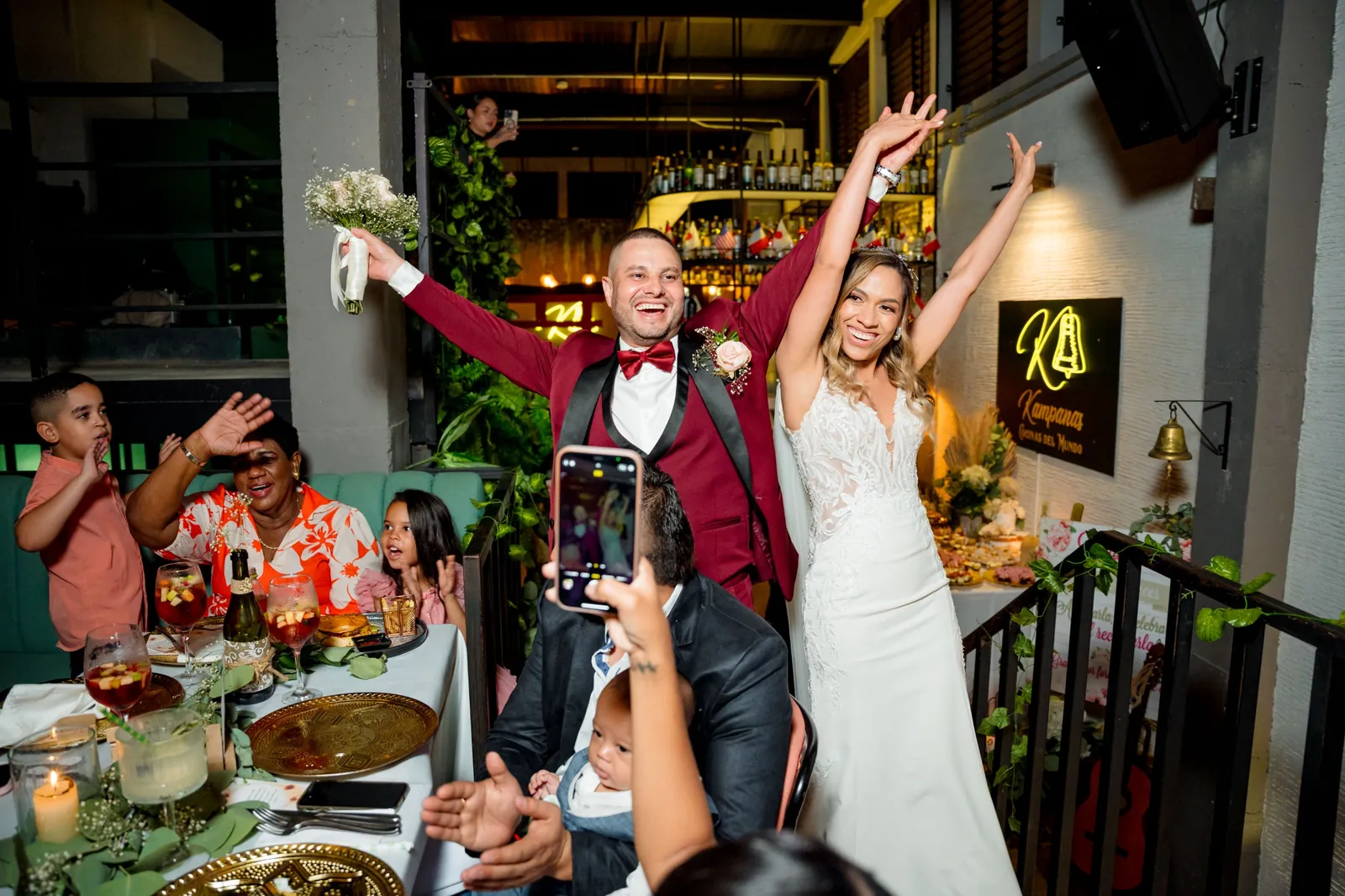 Los novios celebrando con los brazos en alto junto a sus invitados en Kampanas