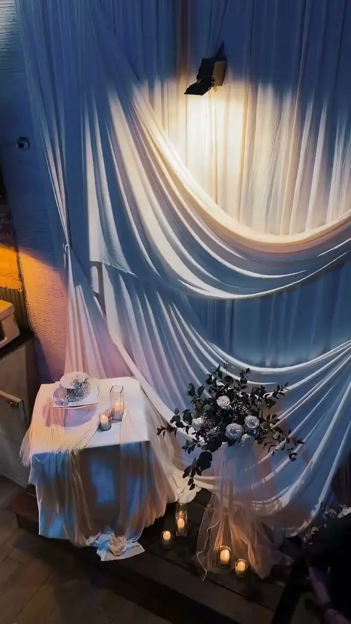 El montaje del salón de Kampanas: telas iluminadas y la mesa del pastel, en una boda real